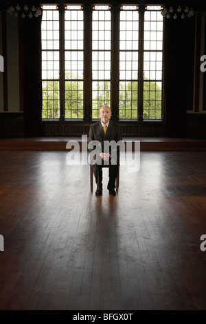 Imprenditore seduti nella grande sala vuota Foto Stock