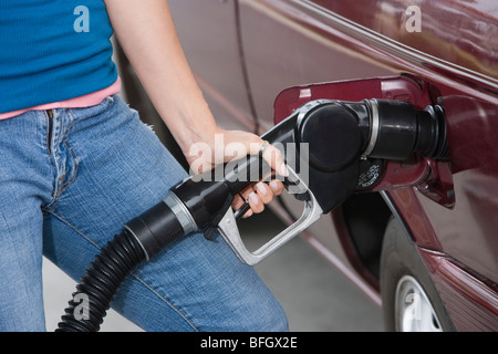 La donna in auto con pompa carburante, metà sezione Foto Stock