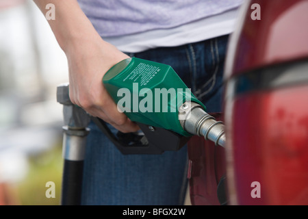 La donna in auto con pompa carburante, metà sezione Foto Stock