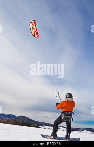Paraskier deltaplano ad alta velocità sulla superficie della neve come il vento soffia nel suo paracadute. Quebec, Canada Foto Stock