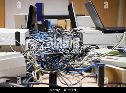 Pasticcio di fili di collegamento tra computer e stampanti in ufficio Foto Stock