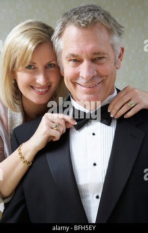 Donna di mezza età di legatura del marito il filtro bow tie, ritratto Foto Stock