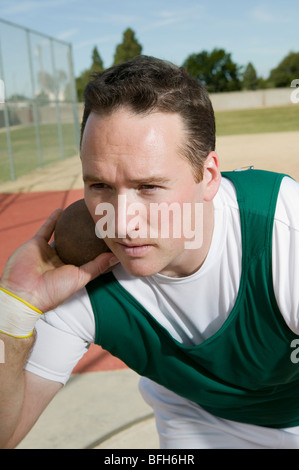 Voce maschile shot putter holding shot Foto Stock