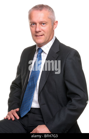 Ritratto di un imprenditore maturo che indossa un abito grigio con cravatta blu, isolata su uno sfondo bianco. Foto Stock