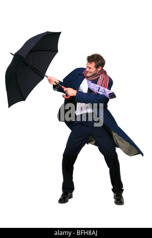 Studio shot di un imprenditore alle prese con un ombrello nel vento, isolata su uno sfondo bianco. Foto Stock