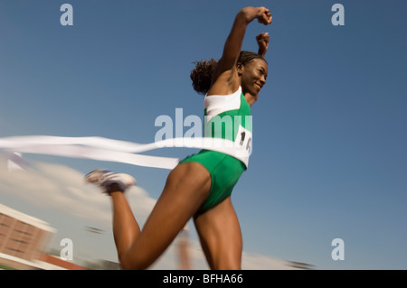 Via femminile atleta di attraversamento della linea di finitura Foto Stock