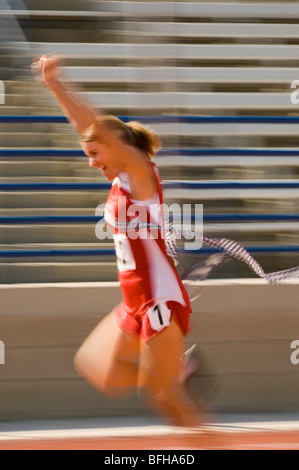 Via femminile atleta di attraversamento della linea di finitura Foto Stock