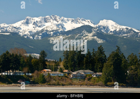 Snow-capped Mount Arrowsmith telai sopra la spiaggia di Parksville BC. Foto Stock