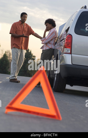 Il triangolo di avvertenza di fronte ripartiti in auto, persone in background Foto Stock