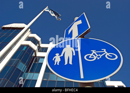 British cartelli stradali che indicano una strada a senso unico, con una freccia bianca, e corsie separate per i ciclisti e i pedoni Foto Stock