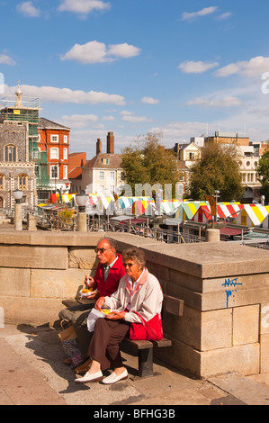 Una coppia di anziani a mangiare Fish & Chips dal mercato a Norwich, Norfolk, Regno Unito Foto Stock