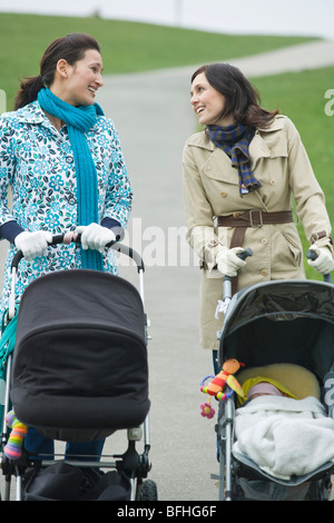 Due madri con i passeggini in parco con chat Foto Stock