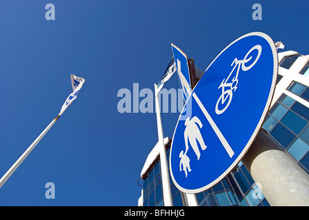 British cartelli stradali che indicano una strada a senso unico, con una freccia bianca, e corsie separate per i ciclisti e i pedoni Foto Stock