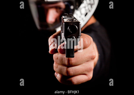 Uomo con moto casco tiene a pistola puntata all viewer - modello rellease disponibile Foto Stock