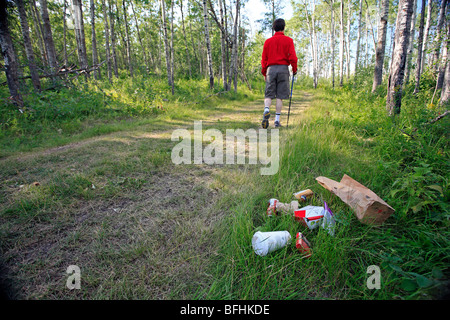 Metà maschio età escursioni sul sentiero forestale con garbage sulla terra. Foto Stock