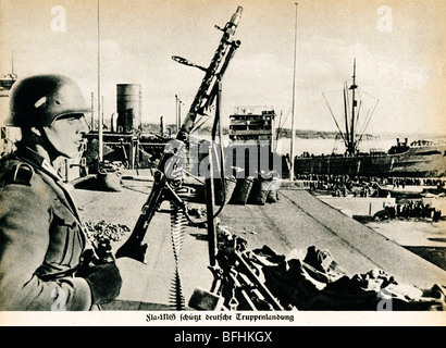 MG 34, Norvegia 1940, una sentinella tedesca con la classica mitragliatrice guarda sulle truppe sbarco durante l'invasione Foto Stock