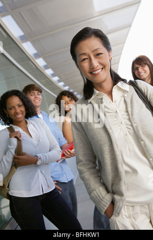 L insegnante e gli studenti sorridente al di fuori della scuola, ritratto Foto Stock