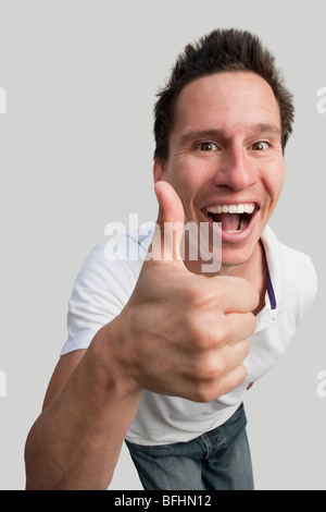 Divertente ritratto di un giovane uomo dando pollice in alto Foto Stock