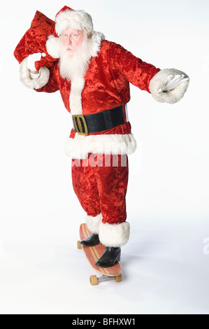 Babbo Natale su skateboard che trasportano il sacco Foto Stock