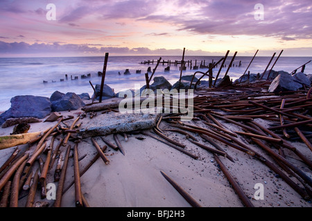 Abbandonate le difese del mare alla prima luce a Happisburgh sulla costa di Norfolk Foto Stock