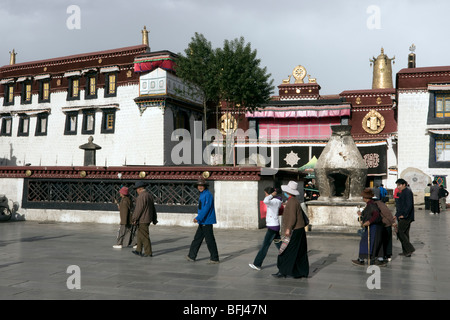 Pellegrini eseguendo il barkhor circuito nella parte anteriore del Jokhang Foto Stock