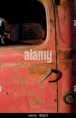 Un rosso ruggine carrello porta e gestire da un vecchio fatiscente 1947 Fargo pickup truck Foto Stock