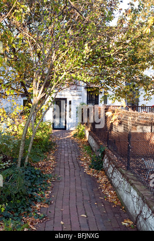 Percorso di mattoni attraverso il tranquillo giardino conduce ad un modesto ingresso appartato di mews house su Coffey Street in Red Hook Brooklyn NY Foto Stock