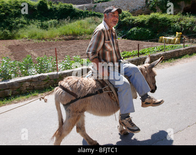 Uomo che cavalca un asino attraverso Dol, isola di Brac, Croazia Foto Stock