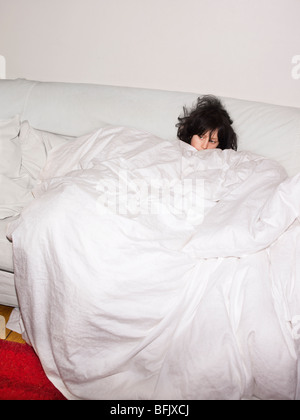 Una stanca ragazza in un divano, Svezia. Foto Stock