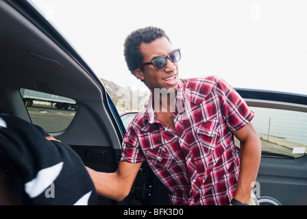 Razza mista uomo rimozione coperta dal retro della macchina Foto Stock