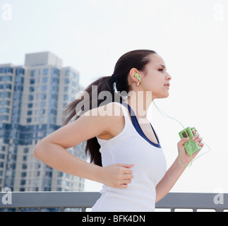 Razza mista donna jogging con lettore mp3 Foto Stock