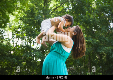 Incinta donna ispanica il sollevamento baby boy Foto Stock