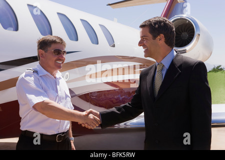 Imprenditore e pilota stringe la mano al di fuori del jet privato Foto Stock