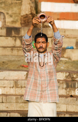 Un uomo che prega nel fiume Gange presso il Hindu città santa di Varanasi, India Foto Stock