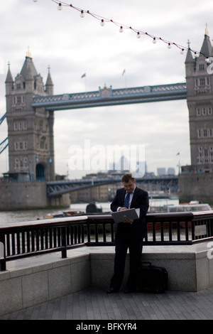 Al fresco e ufficio, Queens a piedi, uomo sul laptop tramite il Tower Bridge di Londra Foto Stock