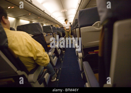 Sicurezza giubbotto di salvataggio istruzioni su aereo, vista di assistente di volo da un corridoio Foto Stock