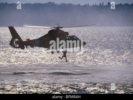Un United States Coast Guard USCG Rescue nuotatore che viene sollevato dal mare Foto Stock