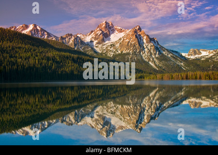 Stati Uniti d'America, Idaho, Sawtooth National Recreation Area. A dente di sega, montagne coperte di neve picco McGowen riflettente nel lago di Stanley. Foto Stock
