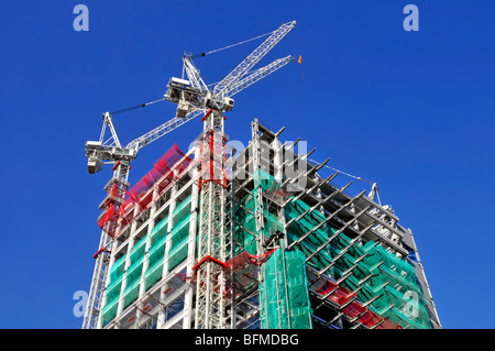 Alto edificio grattacielo sito in costruzione con verde di compensazione di sicurezza & gru a torre divenne la torre di airone nella città di Londra Inghilterra REGNO UNITO Foto Stock