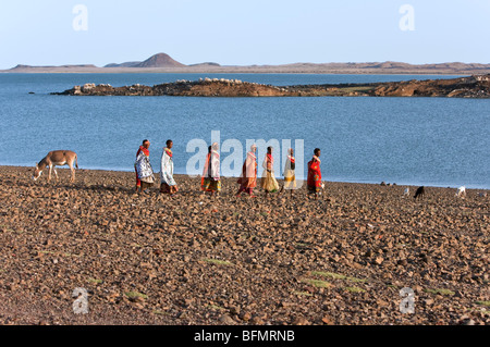 Un gruppo di El Molo le donne a piedi lungo la sterile con la riva del lago Turkana s El Molo Bay. Foto Stock