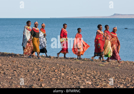 Un gruppo di El Molo le donne a piedi lungo la sterile con la riva del lago Turkana s El Molo Bay. Foto Stock