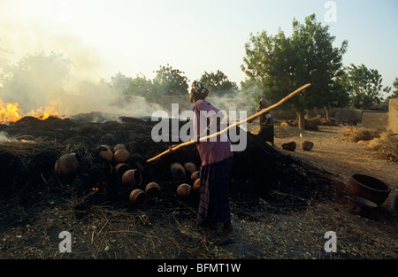 Mali, vicino a Segou, Kalabougou. Una donna rastrelli un incendio in cui in ceramica - di cui il paese è famoso - è cotto. Foto Stock