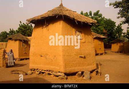 Mali, Promani Village, vicino a Djenne. Gli abitanti di un villaggio di pausa accanto ad un piccolo mattone di fango granaio in cui essi mantengono eccedenze di negozi di generi alimentari. Foto Stock