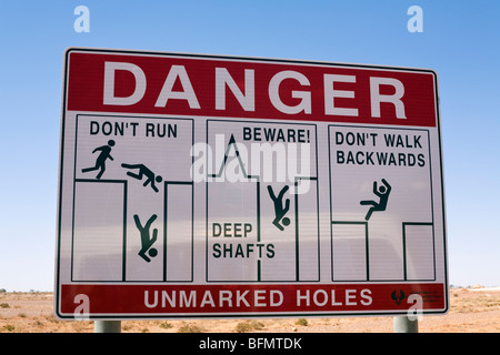 In Australia, in Sud Australia, Coober Pedy. Segnaletica di pericolo di avvertimento di aprire il mio alberi in Coober Pedy opale. Foto Stock