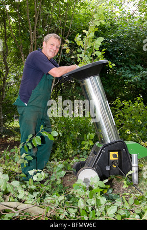 Di mezza età lavoratore forestale con trinciatrice Foto Stock