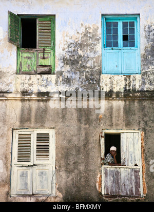 Tanzania, Zanzibar Stone Town. Le finestre con persiane di un vecchio edificio in pietra città. Foto Stock