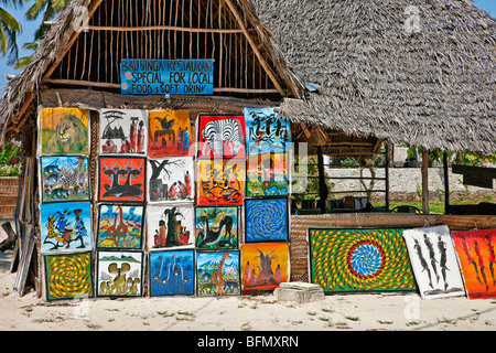 Tanzania, Zanzibar. Un ristorante vendita di dipinti di artisti locali vicino a Paje Beach nel sud-est dell'isola. Foto Stock