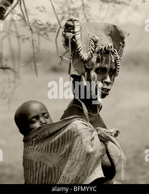 Ethippia, Omo Delta. Una donna dalla tribù dei Mursi con il suo bambino sulla schiena. Foto Stock