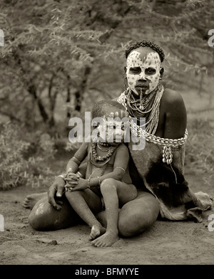 Etiopia, Omo Delta. Una donna dalla tribù Karo, famosi per la loro pittura del viso, con il suo bambino. Foto Stock