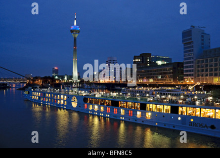 Serata al 'Media porto', Düsseldorf, NRW, Germania con la nave di crociera in partenza. Foto Stock